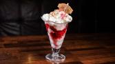 Hot raspberries with homemade ice cream and whipped cream and cherry liqueur